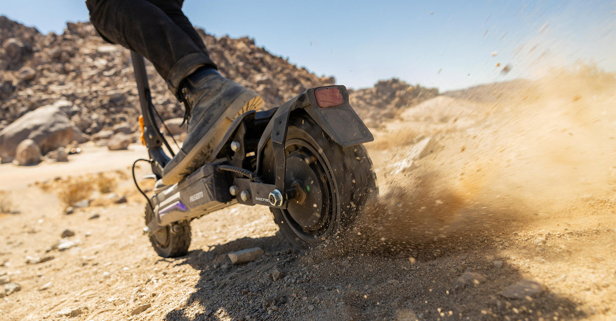 Electric scooter rider kicking up dust on an off-road trail